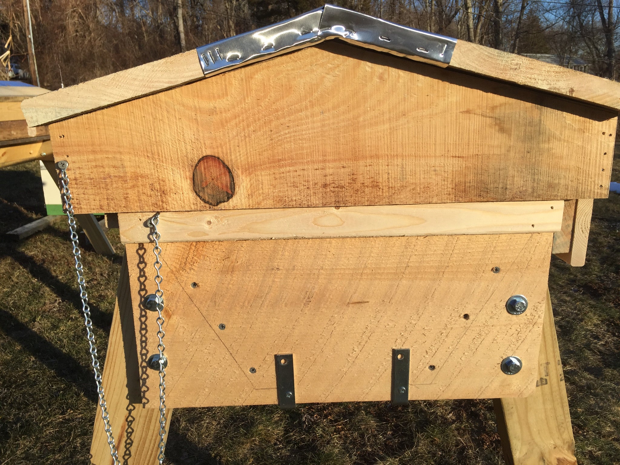 Legs are bolted outside of the hive so you can remove them in the event that you need to move the hive. The bottom board is attached with an L-bracket. It can be hung with a gap below the hive to perform mite counts.